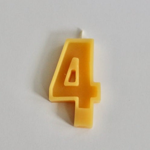 White background with 100% Pure Canadian Beeswax Candle in "4" by Fersk Self Care. Candle is a natural yellow beeswax colour, with the number 4 and a wick on the top