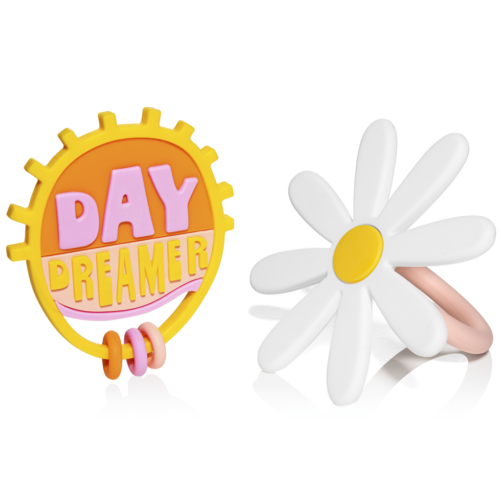 Clear background with Flower Child Teething Toy by Lucy Darling. Left toy is a circle teether that says "Day Dreamer", and right is a big white daisy.