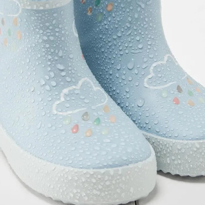 Colour Changing Rain Boots by Grass & Air in Light Blue on a white wood surface. 