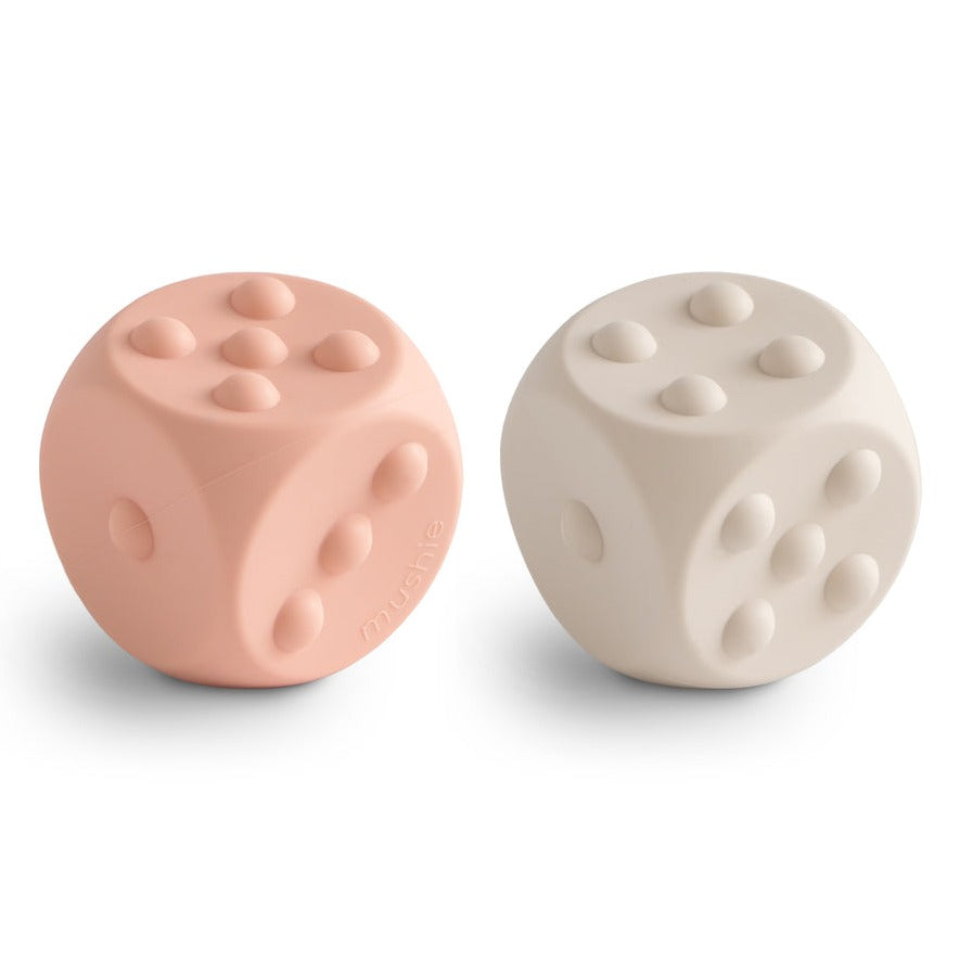 Dice Press Toy 2-Pack by Mushie in Blush and Shifting Sand, white background. 