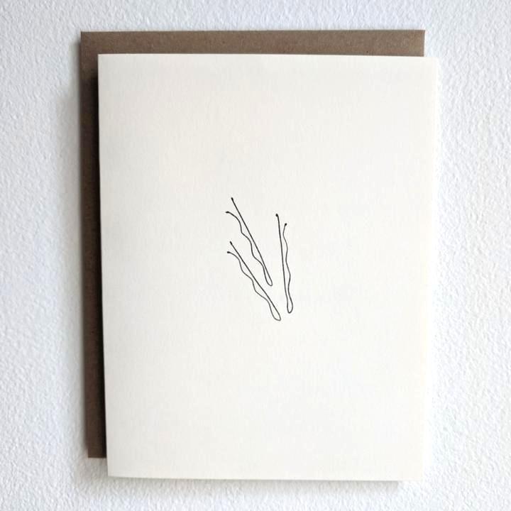 White background with the Bobby Pins Card by Under The Stairs Paper Co. Card is a white colour, with black bobby pins.