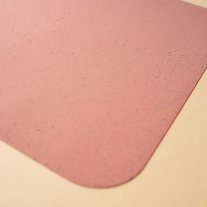 Beige background with a Silicone Placemat in Sorbet by Minika. Placemat is square silicone, in a rose speckled colour.