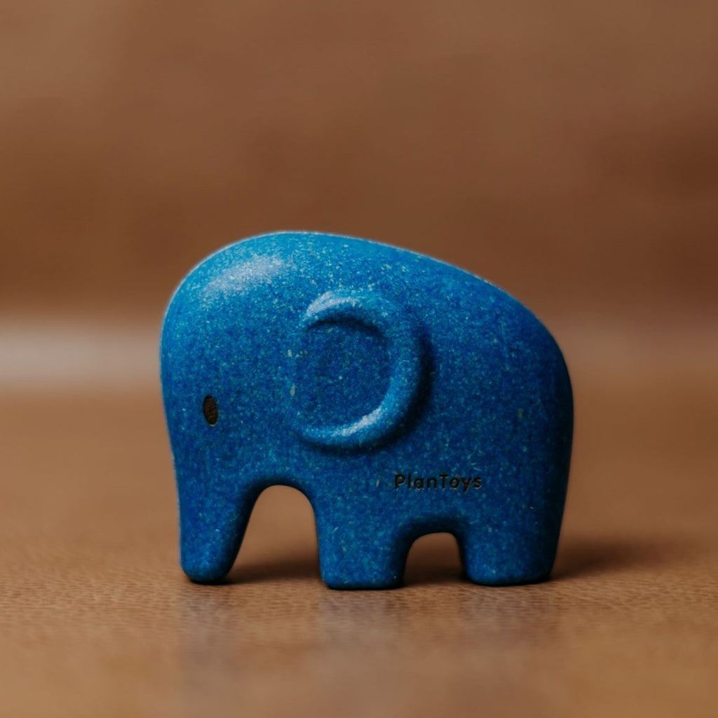 Brown background with Elephant by PlanToys. Elephant is a dark blue colour.