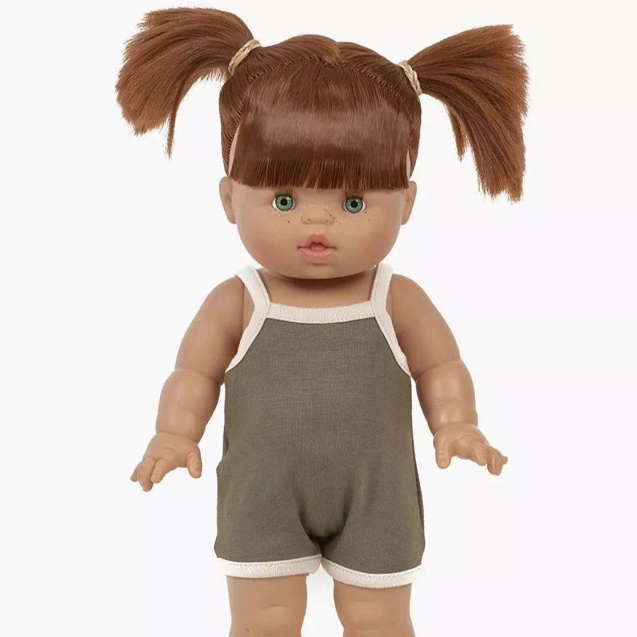 White background with Gabriella Doll by Minikane. Doll has light skin, green eyes, red hair, and is wearing a spaghetti strap romper in sage green.