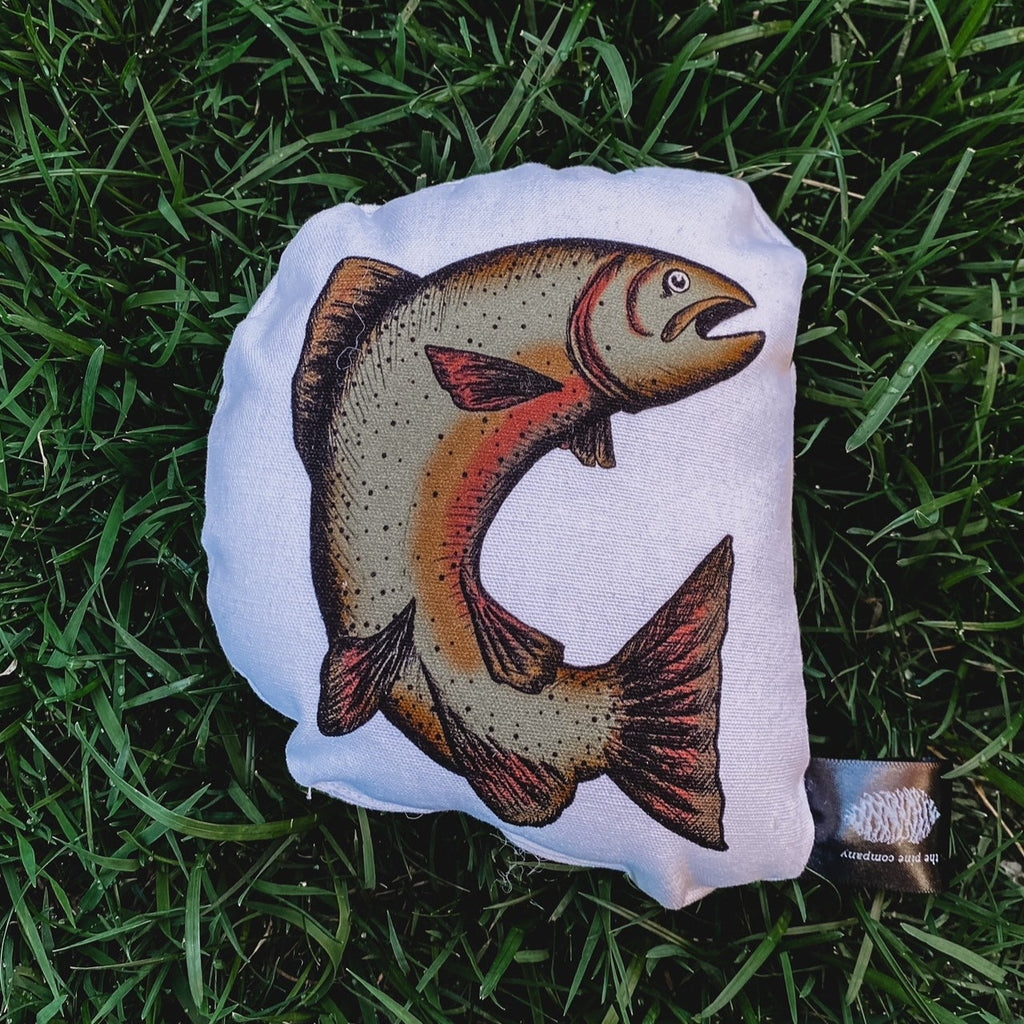 Overhead view of the Acorn Collection Rattle in Trout by The Pine Company, laying in grass.