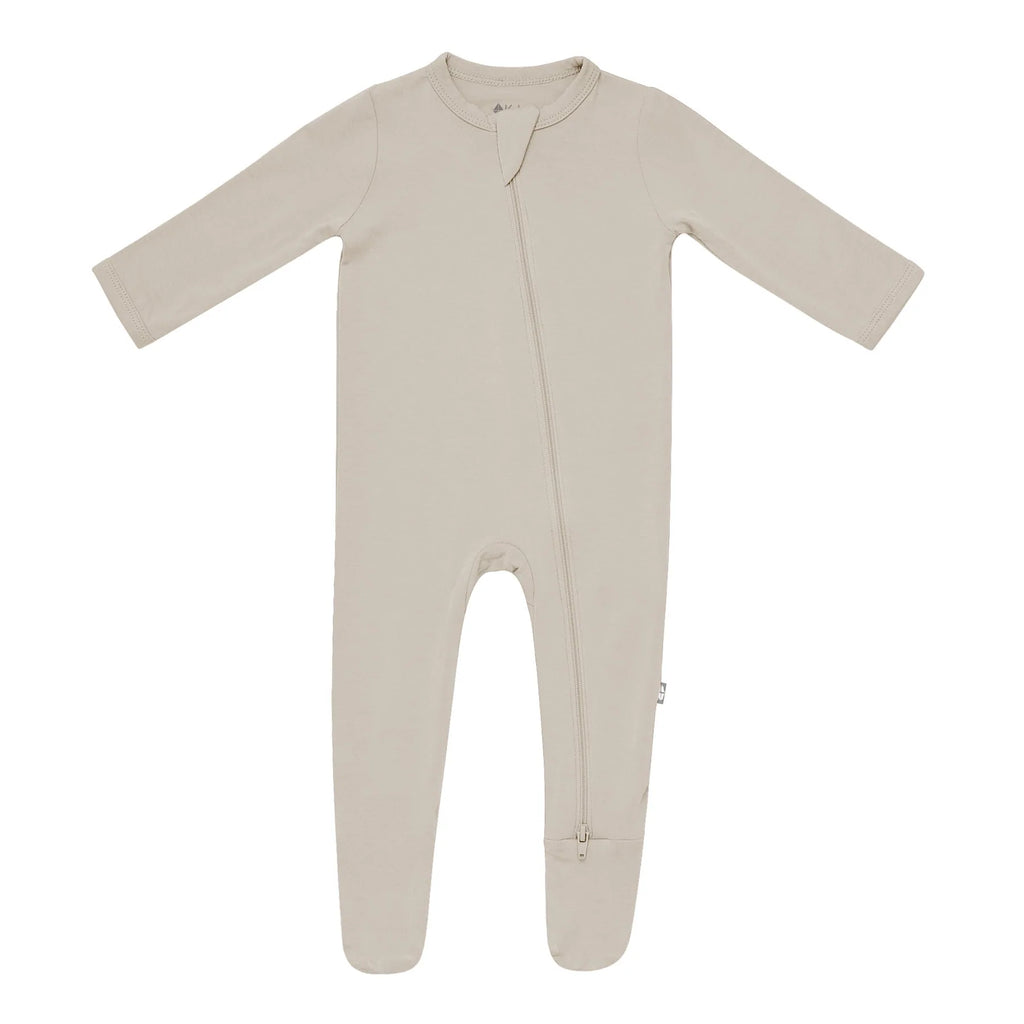 White background with a Zippered Footie in Khaki by Kyte Baby. Zippered footie in beige khaki with a zipper going down the front.