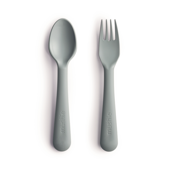 White background with Fork and Spoon Set in Sage by Mushie. They come in a beautiful sage colour.