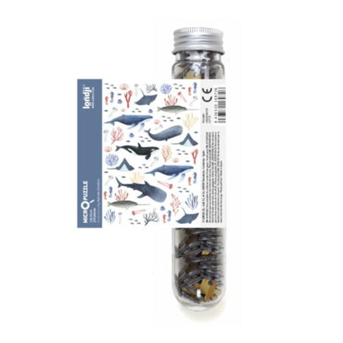 White background with a Wildlife Mix Micropuzzle by Londji. Puzzle comes in a clear tube.
