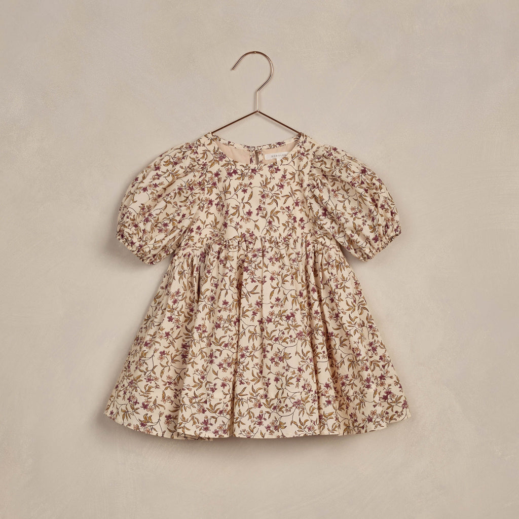 flatlay of fig floral dress on beige background 