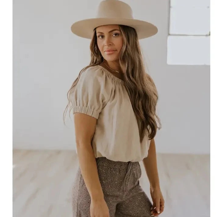 side of top women wearing hat and brown floral pant 