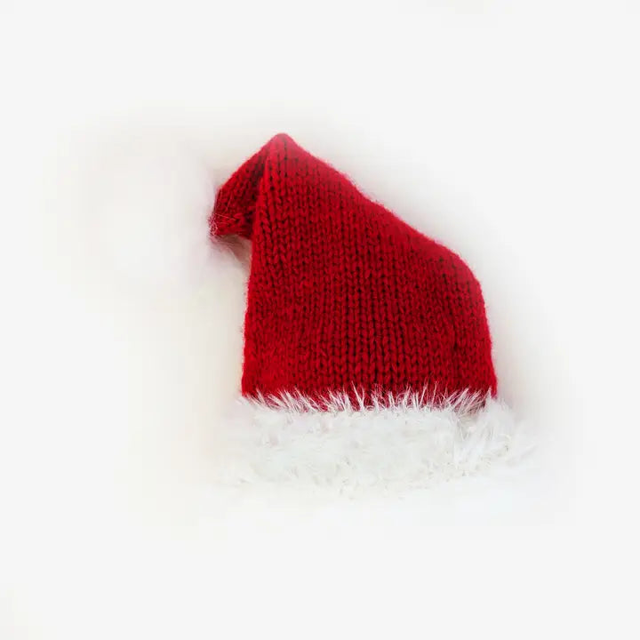 flatlay of red santa hat with pom on top white background 