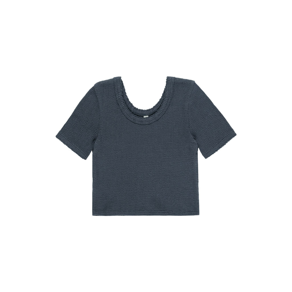 flatlay of indigo scalloped tee on white background 