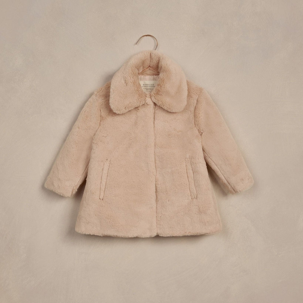 flatlay of fur antique coat on beige background 