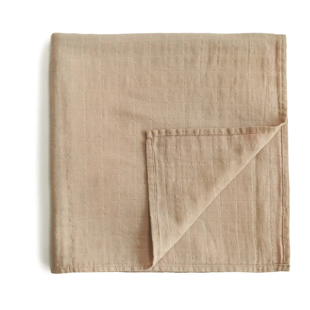 pale taupe muslin swaddle on white background flatlay 