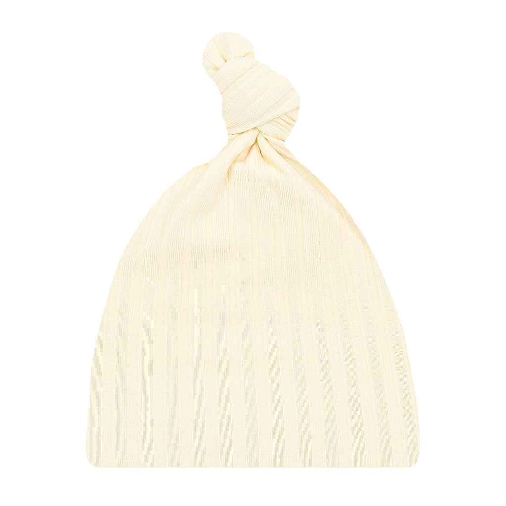 flatlay of ribbed knot hat on white background 