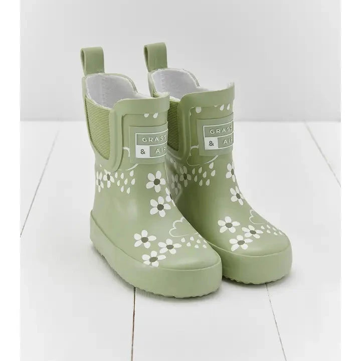 flatlay of green rubber boot on white background 