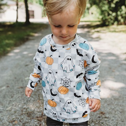 spooky ghost halloween sweater on little boy outside 