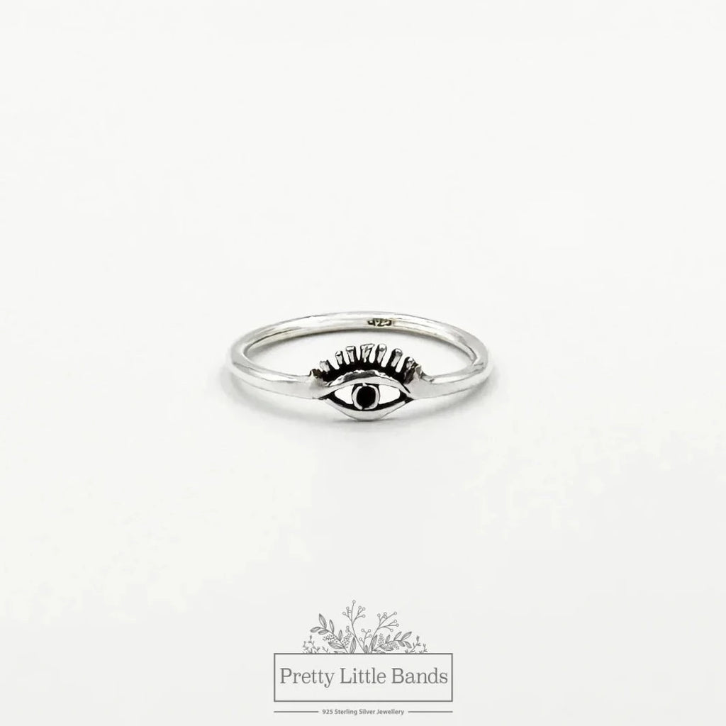 flatlay of evil eye ring on white background
