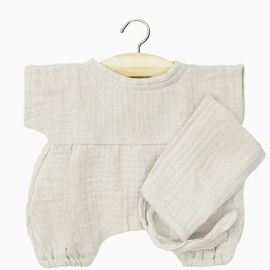 flatlay of white gauze romper on hanger white background 