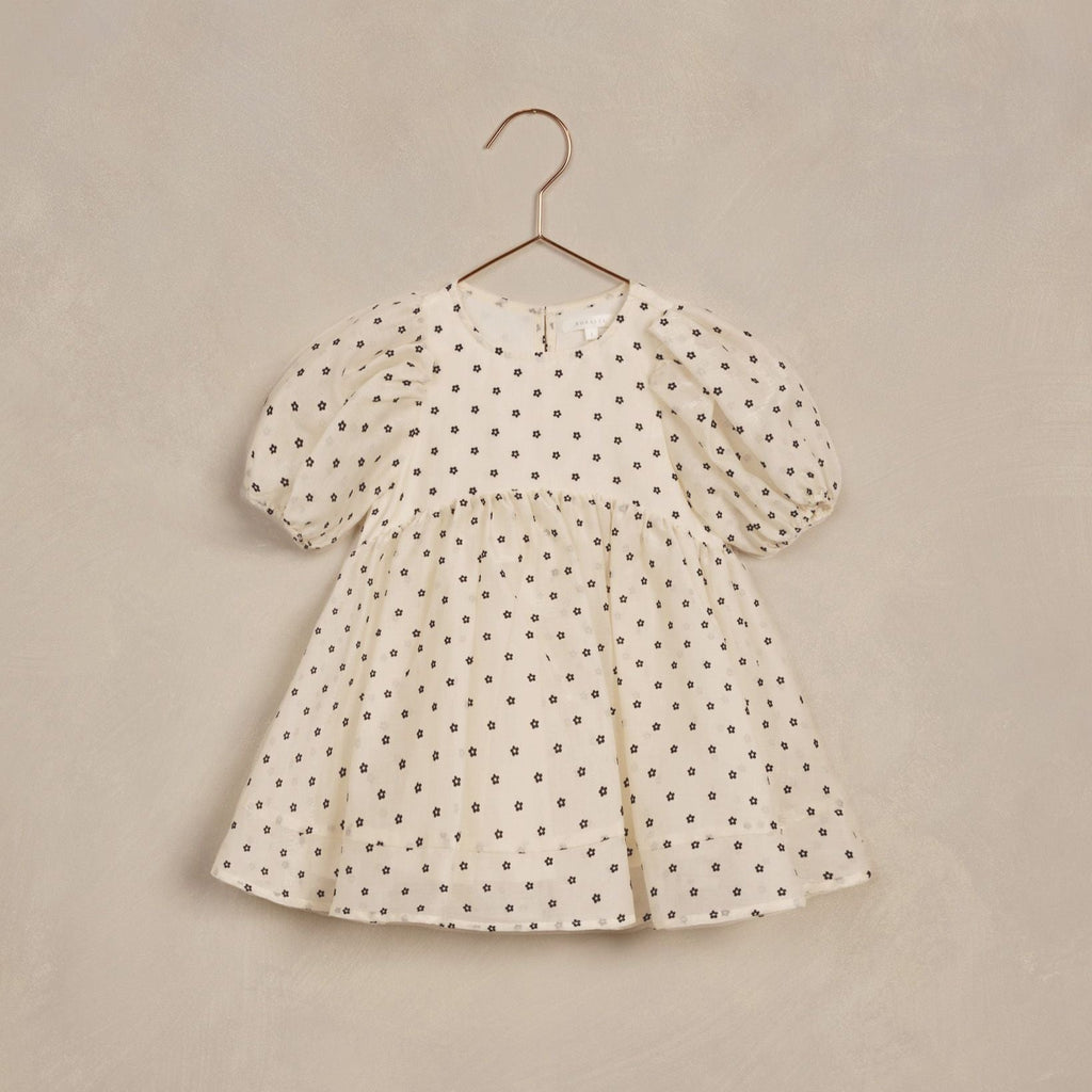 flatlay of daisy dress in ivory on white background 