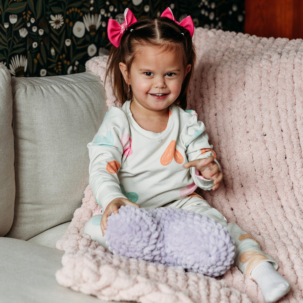 little girl with pink bows in hair and hearts sweatshirt