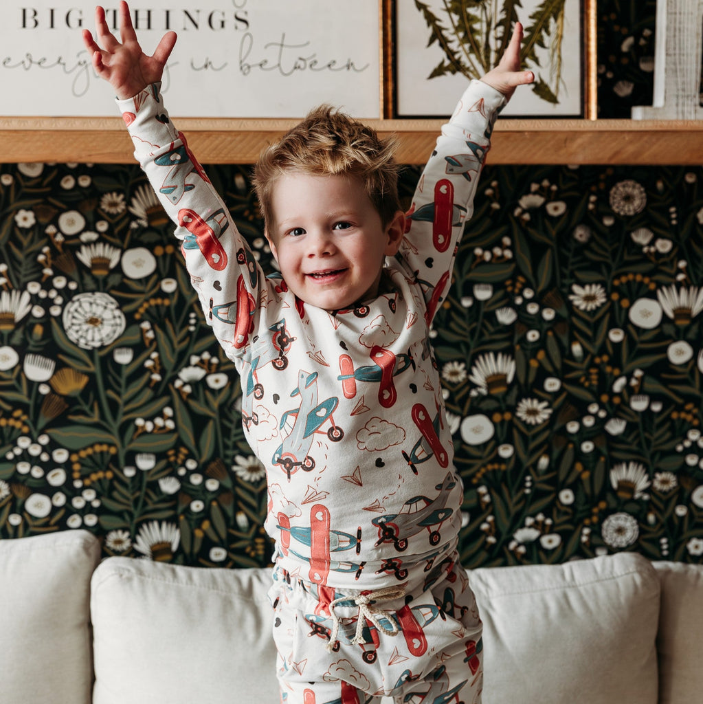 little boy with hands in air with tracksuit in planes