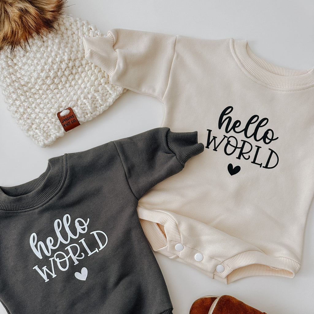 flatlay of hello world romper  with toque