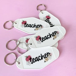 white teacher keychain on pink background