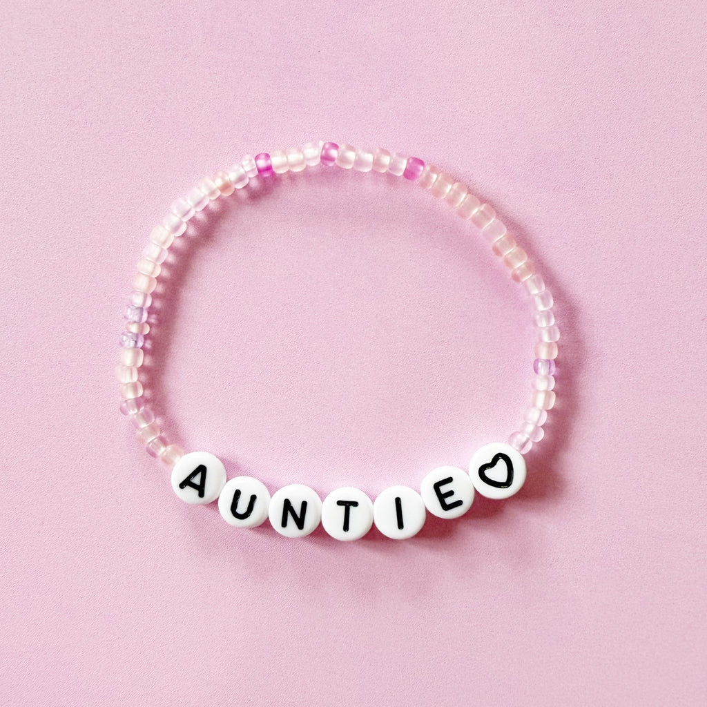 auntie bracelet with pink beads black heart flat lay