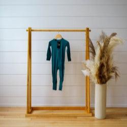 green zip sleeper hanging on wooden rack 