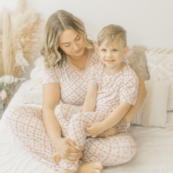 Little boy sitting on womans lap in smiley pjs