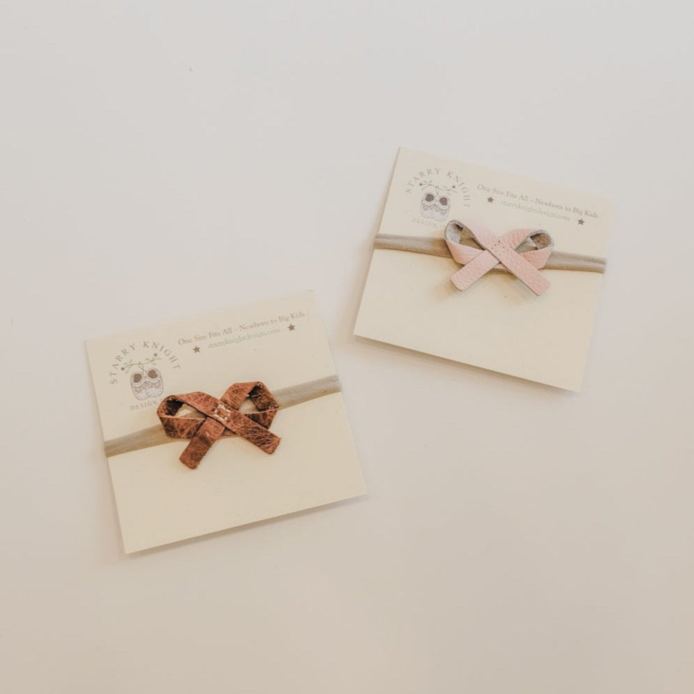 White background with the Ballet Bow Headbands by Starry Knight Design, in the packaging. Showing both colours.