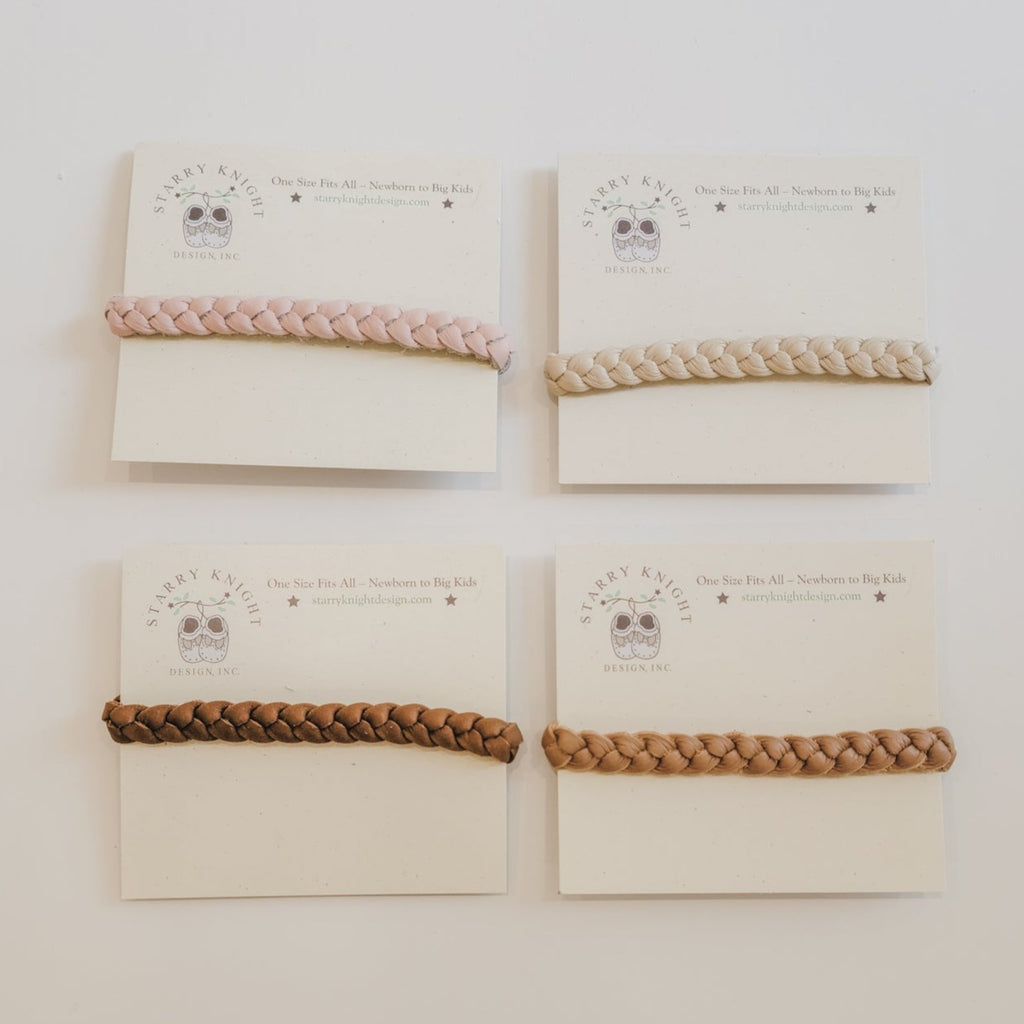 White background with the Braided Headbands by Starry Knight Design. Showing all 4 colours laid out in the packaging.