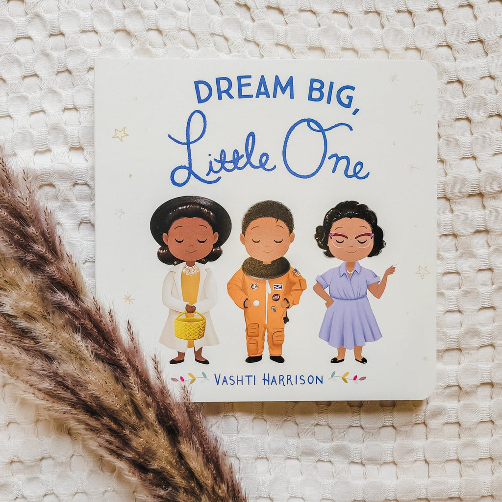 Cream waffle blanket with pampas grass on the bottom left side and the book Dream Big, Little One. Cover is a beige colour with 3 women on it.