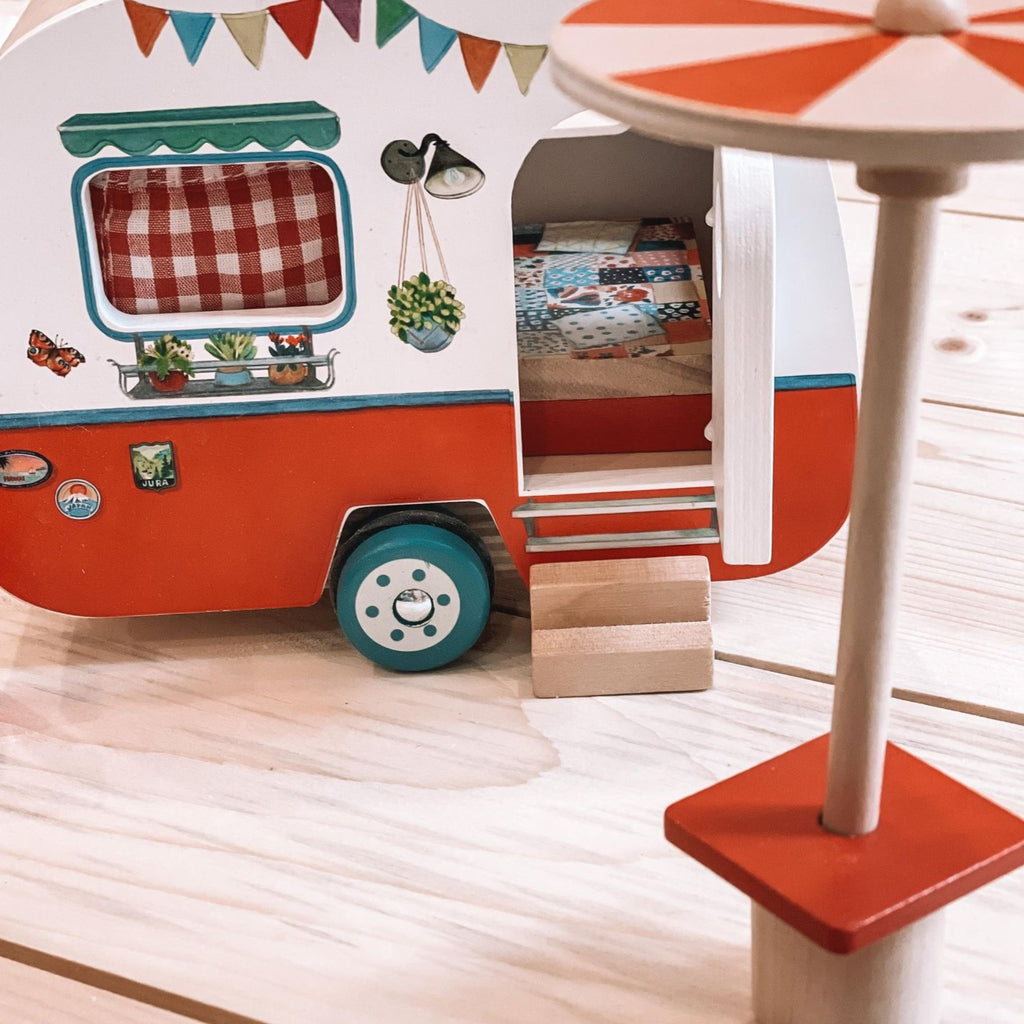 Wood floor background with the Grande Famille Caravan by Moulin Roty. This is an up close view of the front of the caravan, showing the small details of the little steps.