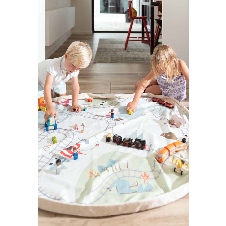 Side view of girl and boy playing with the Trainmap / Happy Bears Playmat & Storage Bag by Play & Go. 