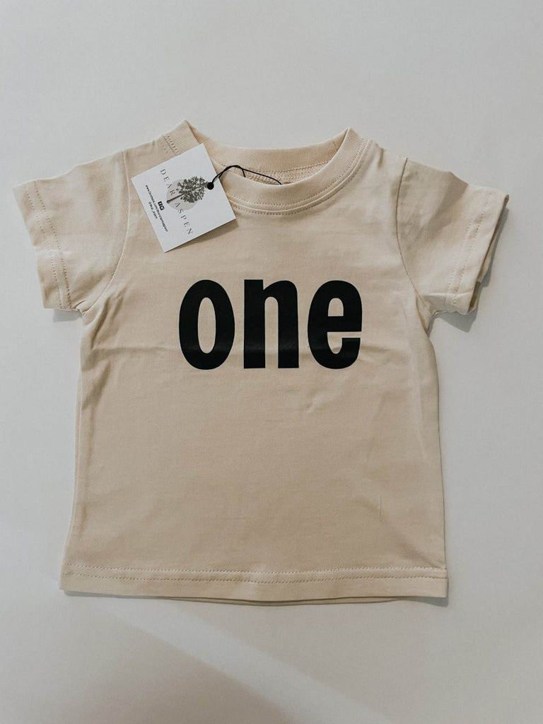 one birthday tee by Dear Aspen, laid on a flat white surface. 