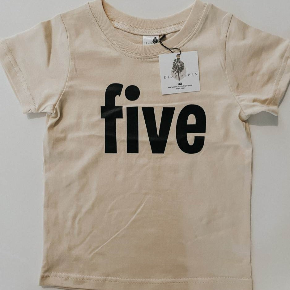 five birthday tee by Dear Aspen, laid on a flat white surface. 
