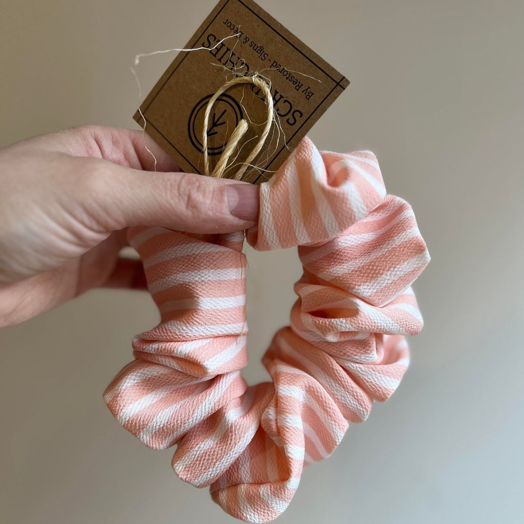 Jumbo Scrunchies by Restored Signs & Decor pink and white stripe scrunchie held against beige wall
