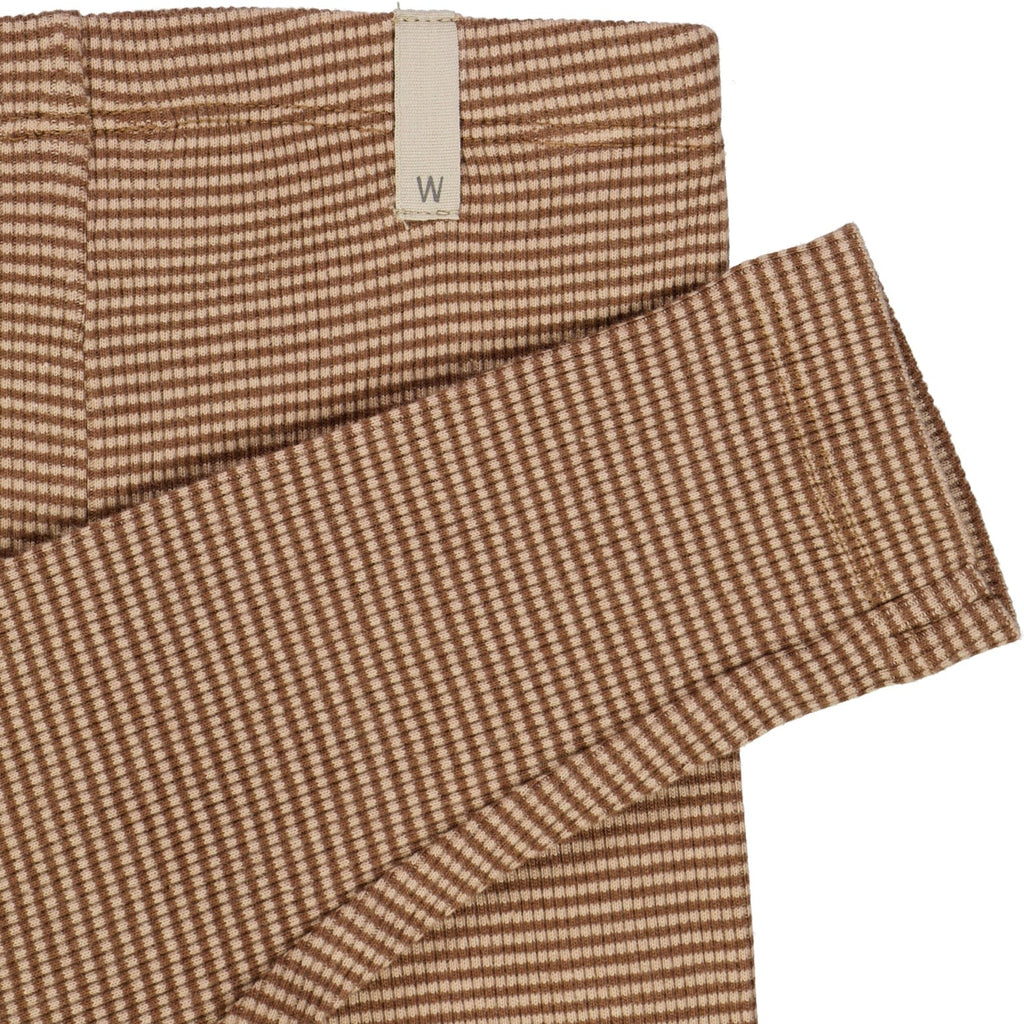 White background with a close up of the Jersey Leggings in Affogato Stripe by Wheat Kids Clothing. Leggings are made of a jersey material, in a brown and light brown stripe.
