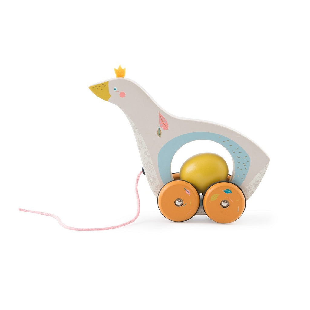 White background with Goose and Egg Pull Along by Moulin Roty. This is a wooden goose with an egg in it's belly, and it has a pink string to pull it. The goose is white with accents of orange, and yellow.