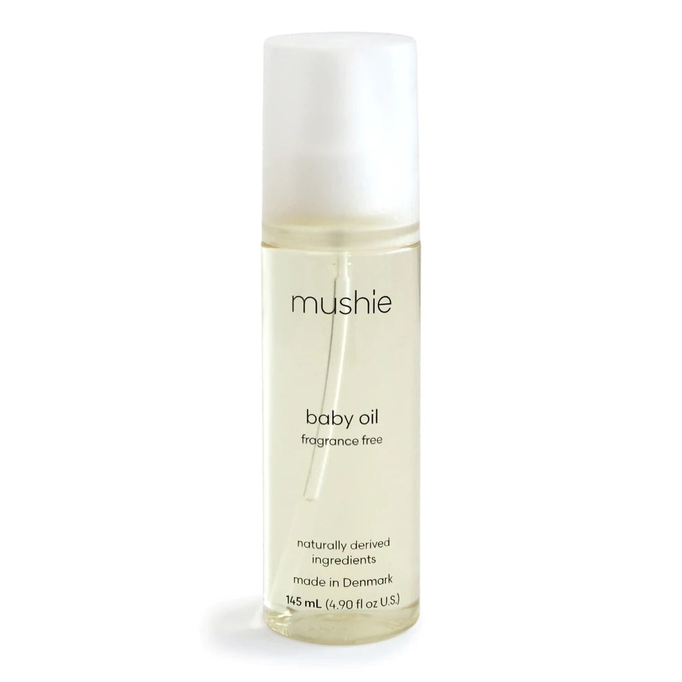 White background with Baby Oil by Mushie. Baby oil comes in clear bottle.