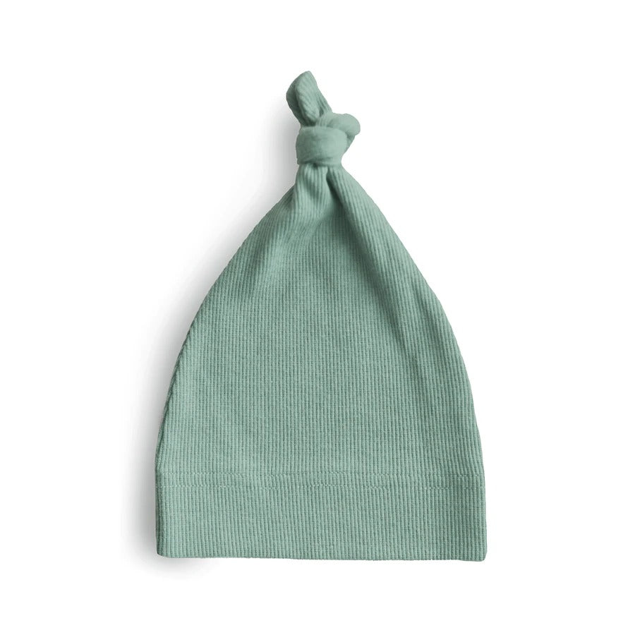 White background with Ribbed Baby Beanie in Roman Green. Beanie is a ribbed green with a knot on the top.