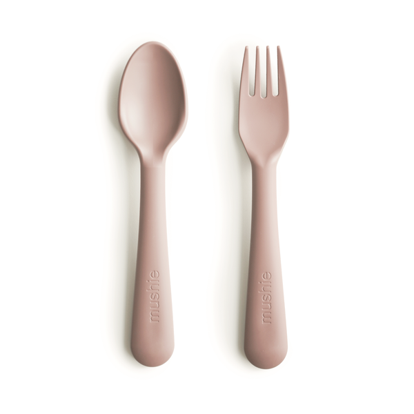 White background with Fork and Spoon Set in Blush by Mushie. They come in a beautiful blush colour.