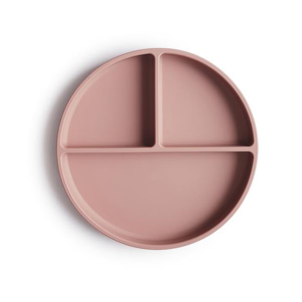 White background with a Silicone Suction Plate in Blush by Mushie. Plate is rounded with 3 compartments, 2 smaller, and 1 larger, in a blush colour.