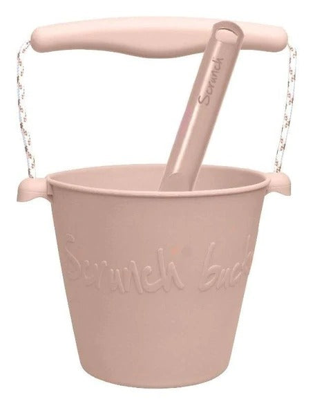White background with the Scrunch Bucket & Spade in Blush by Scrunch Kids. Bucket is a warm blush colour.