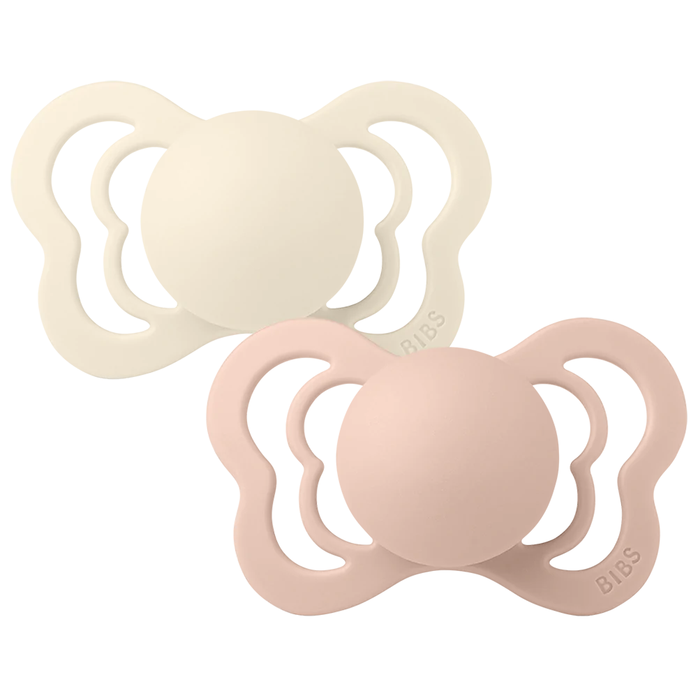 Clear background with the Couture Size 1 Pacifiers in Ivory & Blush by Bibs. Set comes with 1 ivory, and 1 blush pacifier, both shaped like a butterfly.