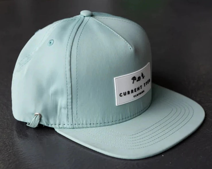 Made for Shae'd Waterproof Hat in Mint by Current Tyed Clothing. On a flat black surface. 