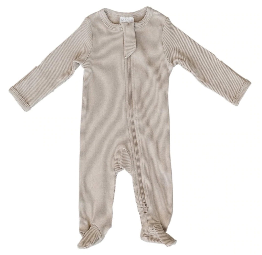 White background with Oatmeal Organic Ribbed Footed Zipper One-Piece by Mebie Baby. One piece is an oatmeal ribbed with a zip down the front, and footies.