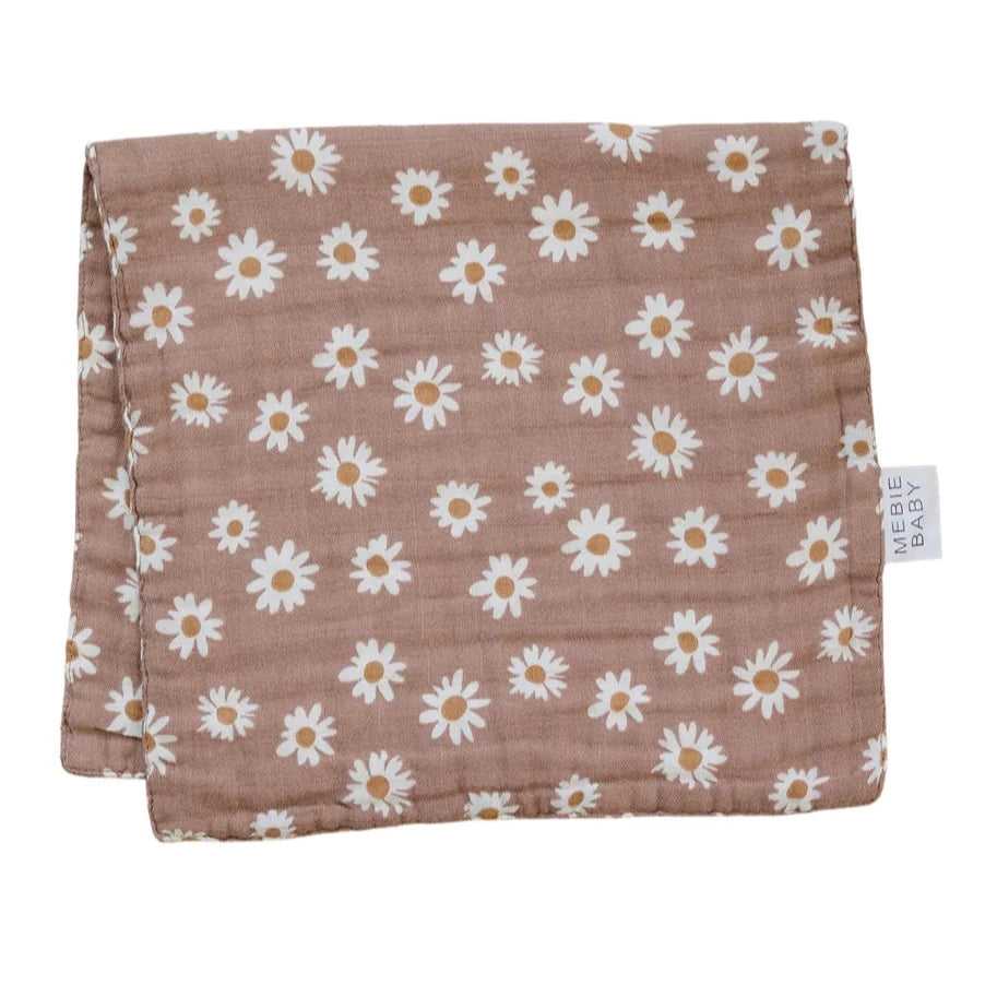White background with Daisy Dream Burp Cloth by Mebie Baby. Bburp cloth is a mauve colour with white daisies all over, and a white tag that says "Mebie Baby".